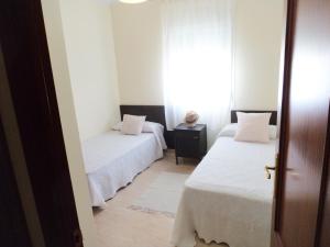 克莉絲蒂娜島的住宿－Isladescanso，一间卧室设有两张床和窗户。