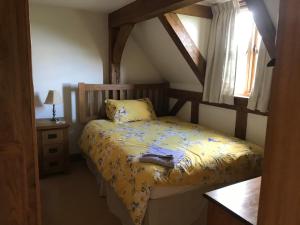 a bedroom with a bed with yellow sheets and a window at Cosy Cottage in the Countryside in Stafford