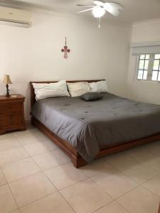 Schlafzimmer mit einem Bett und einem Deckenventilator in der Unterkunft Casa Duplex Privada con Piscina with Ride from Airport in Panama-Stadt