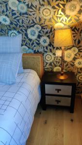 a bedroom with a bed and a lamp on a night stand at Les coquelicots - Chambre Babette in Houdan