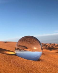 a glass ball in the sand in the desert at Sahara Majestic Luxury Camp in Merzouga