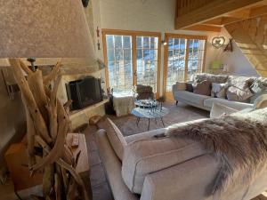 a living room with a couch and a tv at Chalet Pierre Blanche in Nendaz