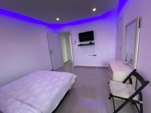 um quarto com uma cama e uma televisão na parede em Eilat-Inn Suites em Eilat