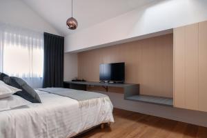 a bedroom with a bed and a flat screen tv at Guesthouse Frlan in Ozalj
