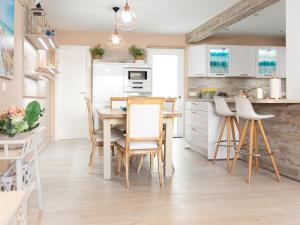 a kitchen with white cabinets and a table and chairs at El Rincón de la Buti in La Cala de Mijas