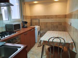 a kitchen with a table and a sink and a washing machine at 2 rooms unirii in Bucharest