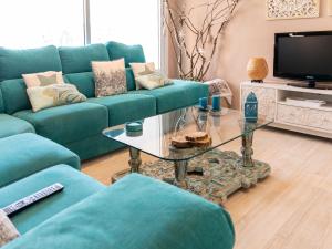 a living room with a blue couch and a tv at El Rincón de la Buti in La Cala de Mijas