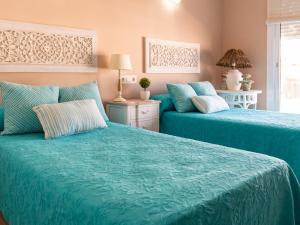 two beds in a room with blue sheets at El Rincón de la Buti in La Cala de Mijas