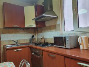 a kitchen with a microwave and a stove top oven at 2 rooms unirii in Bucharest
