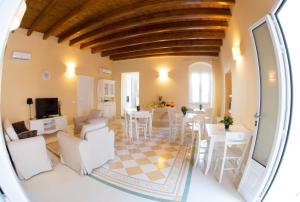 a living room with white furniture and a dining room at B&B Monsignore in Vieste