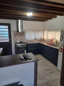 a kitchen with a stove and a counter top at Hermosa casa con patio, parrilla y garage cerrado in Tandil