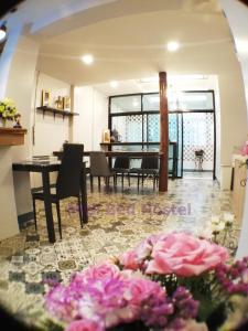 sala de estar con mesa y flores rosas en MIEL BED Hostel & Gallery en Chiang Mai