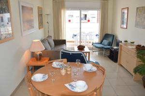 - un salon avec une table et des verres à vin dans l'établissement Apartamentos Estartit Park, à L'Estartit