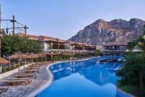 a pool at a resort with a mountain in the background at Atlantica Holiday Village Rhodes in Kolimbia