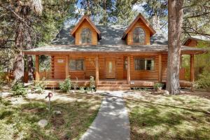 a log cabin in the woods with a pathway in front at Dreams of Summit-1120 by Big Bear Vacations in Big Bear Lake