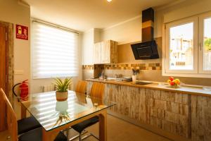 a kitchen with a glass table and a counter at Apartamentos Turísticos Cúllar Vega in Cúllar-Vega