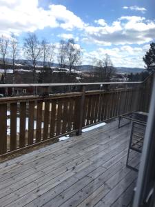 a deck with a wooden railing and a bench on it at Järvsö Kramstatjärnsvägen 10E in Järvsö