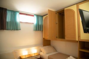 mały pokój z łóżkiem i telewizorem w obiekcie I SUONI DEL MARE w mieście Porto San Giorgio