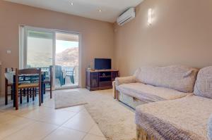 ein Wohnzimmer mit einem Sofa und ein Esszimmer mit einem Tisch in der Unterkunft La Castagna Apartments in Kotor
