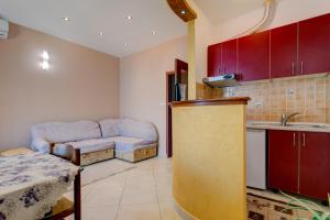 eine Küche mit roten Schränken und einem Sofa in einem Zimmer in der Unterkunft La Castagna Apartments in Kotor