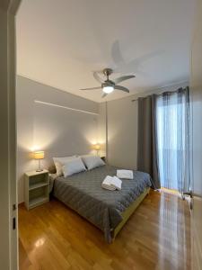 um quarto com uma cama e uma ventoinha de tecto em Ageliki's Athens Apartment em Atenas