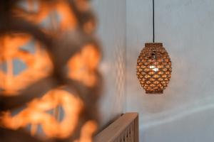 a hanging light fixture in a room with a wall at Almyra Oia Suites in Oia