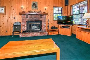 a living room with a fireplace and a television at Breezy Two-113 by Big Bear Vacations in Big Bear Lake