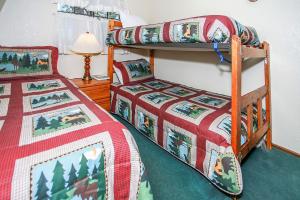 a bedroom with two bunk beds and a lamp at Breezy Two-113 by Big Bear Vacations in Big Bear Lake