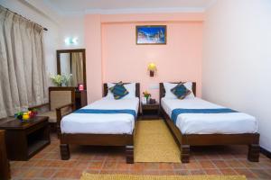 Kathmandu Embassy Hotel tesisinde bir odada yatak veya yataklar