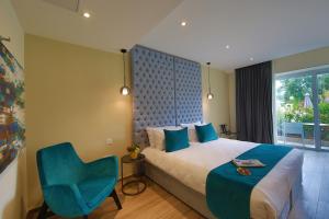 sypialnia z łóżkiem i niebieskim krzesłem w obiekcie Urban Valley Resort & Spa w mieście San Ġwann