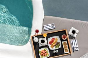 a table topped with plates of food and drinks at La Perla Villas and Suites - Adults Only in Oia