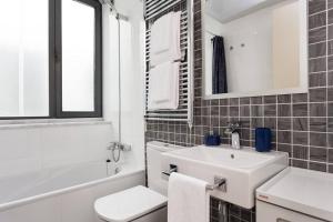 a white bathroom with a sink and a toilet at Modern Luxury Apartment Fira Bcn in Hospitalet de Llobregat