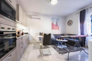 een keuken en een woonkamer met een bank en een tafel bij LUXURY APARTMENT ZADAR OLD CITy in Zadar