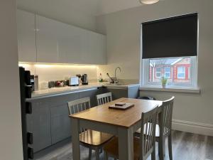 cocina con mesa y sillas en una habitación en Entire spacious 4 bedroom apartment in Bournemouth, en Bournemouth
