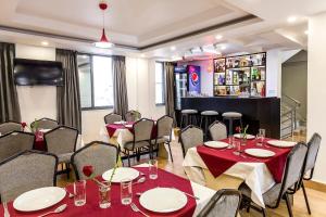un ristorante con tavoli e sedie e un bar di OYO 123 Hotel Prince Plaza a Kathmandu