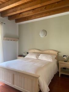 sypialnia z białym łóżkiem i drewnianym sufitem w obiekcie Locanda Arizona w mieście Bardolino