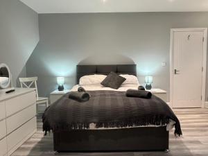 um quarto com uma cama grande e um edredão preto em Entire spacious 4 bedroom apartment in Bournemouth em Bournemouth