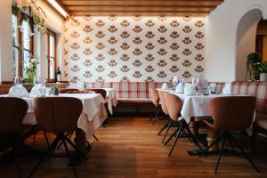 a row of tables in a restaurant with white tablecloths at Landhotel Lindenhof in Feld am See