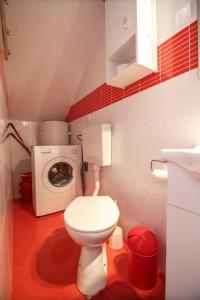a small bathroom with a toilet and a washing machine at Beachfront Love Nest in Komiža
