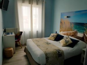 ロワイヤンにあるThe Originals Access, Hôtel Corinna, Royanのベッドルーム1室(壁に絵画が描かれたベッド1台付)