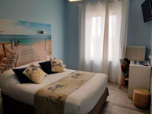 a bedroom with a bed with a view of the beach at The Originals Access, Hôtel Corinna, Royan in Royan