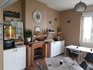 eine Küche mit Kamin und einer Uhr an der Wand in der Unterkunft The Originals Access, Hôtel Corinna, Royan in Royan