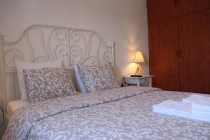 1 dormitorio con 1 cama con cabecero blanco y almohadas en Baou House, en Metsovo