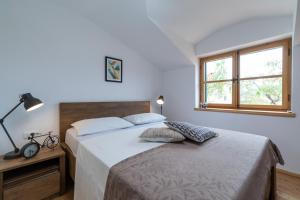 Un dormitorio con una cama grande y una ventana en Komun Apartments en Vela Luka