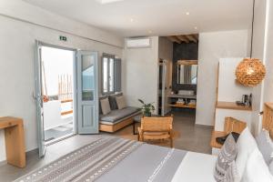 Un dormitorio con una cama y una sala de estar. en Almyra Oia Suites, en Oia