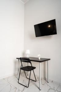 een zwart bureau met een stoel en een televisie aan de muur bij San Felice Palace in Napels