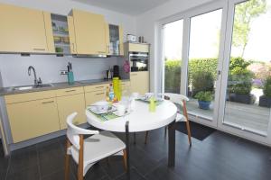 a kitchen with a white table and white chairs at schöne 2-Raum-Ferienwohnung mit Terrasse - Haus Ostseeblick 1 FeWo Steuerbord in Lohme