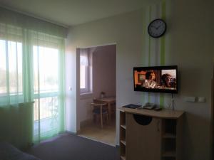 Cette chambre dispose d'une télévision sur un mur et d'une table. dans l'établissement Sweet Apartman Zalakaros, à Zalakaros