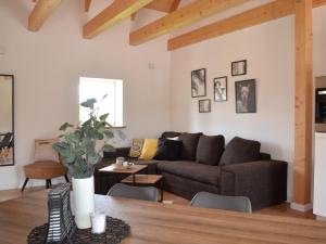 uma sala de estar com um sofá e uma mesa em Skandinavische Ferienwohnung auf Gut Bennewohld JH em Heide