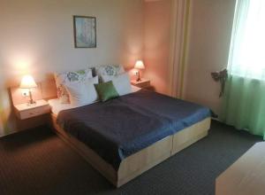a bedroom with a large bed with two tables and two lamps at Sweet Apartman Zalakaros in Zalakaros +54 photos